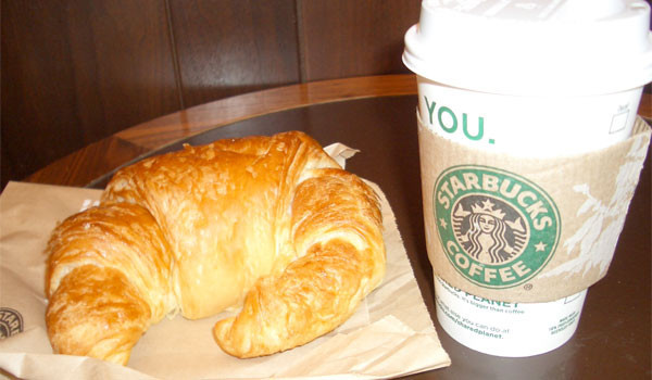 Cup of Starbucks coffee and butter croissant