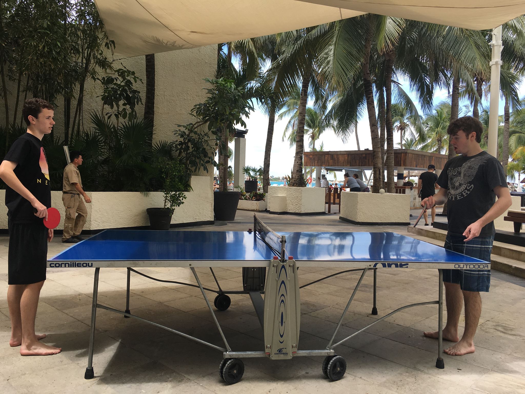 Boys playing ping pong at cancun mexico resort