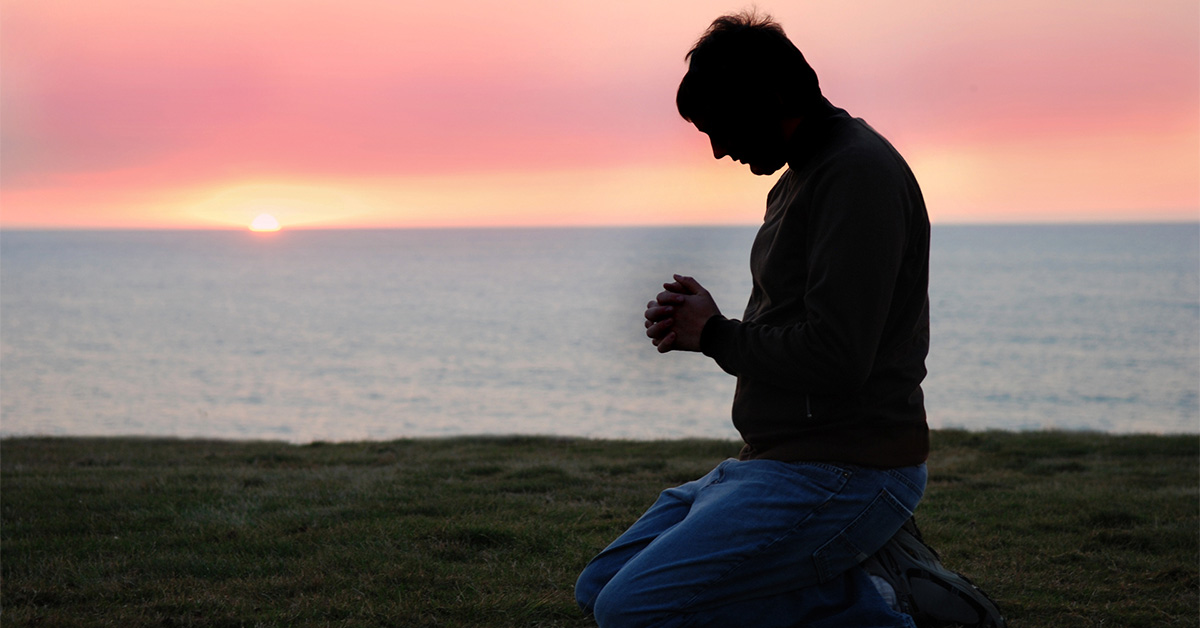 Man praying to God on his knees